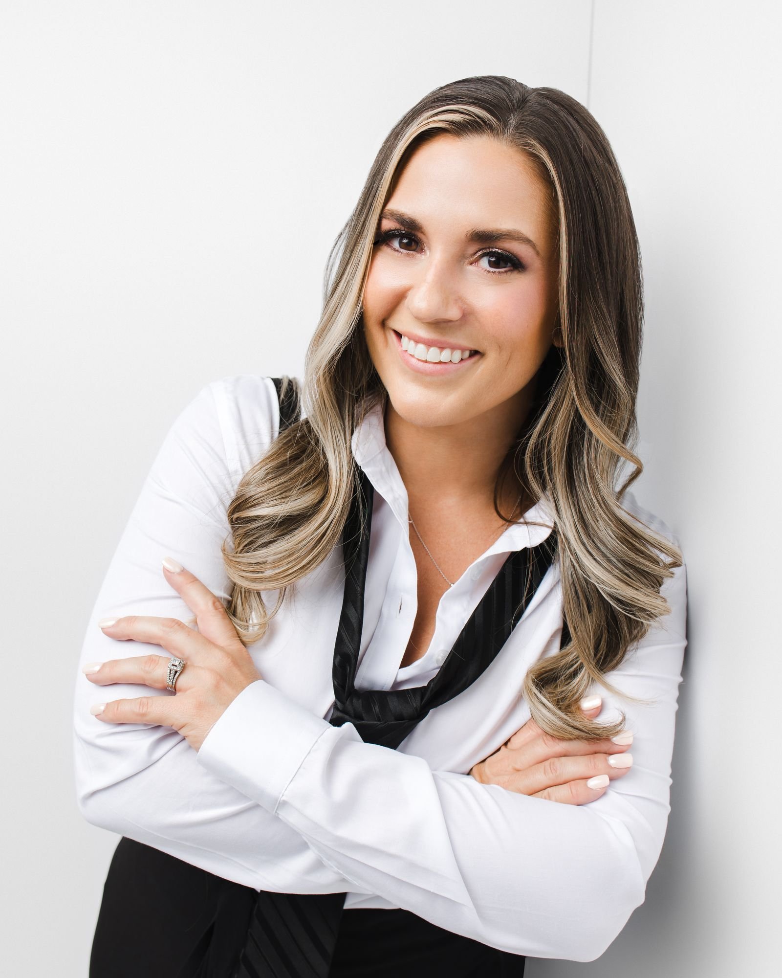 Jessica Pickles, transformation coach, standing with arms folded and smiling